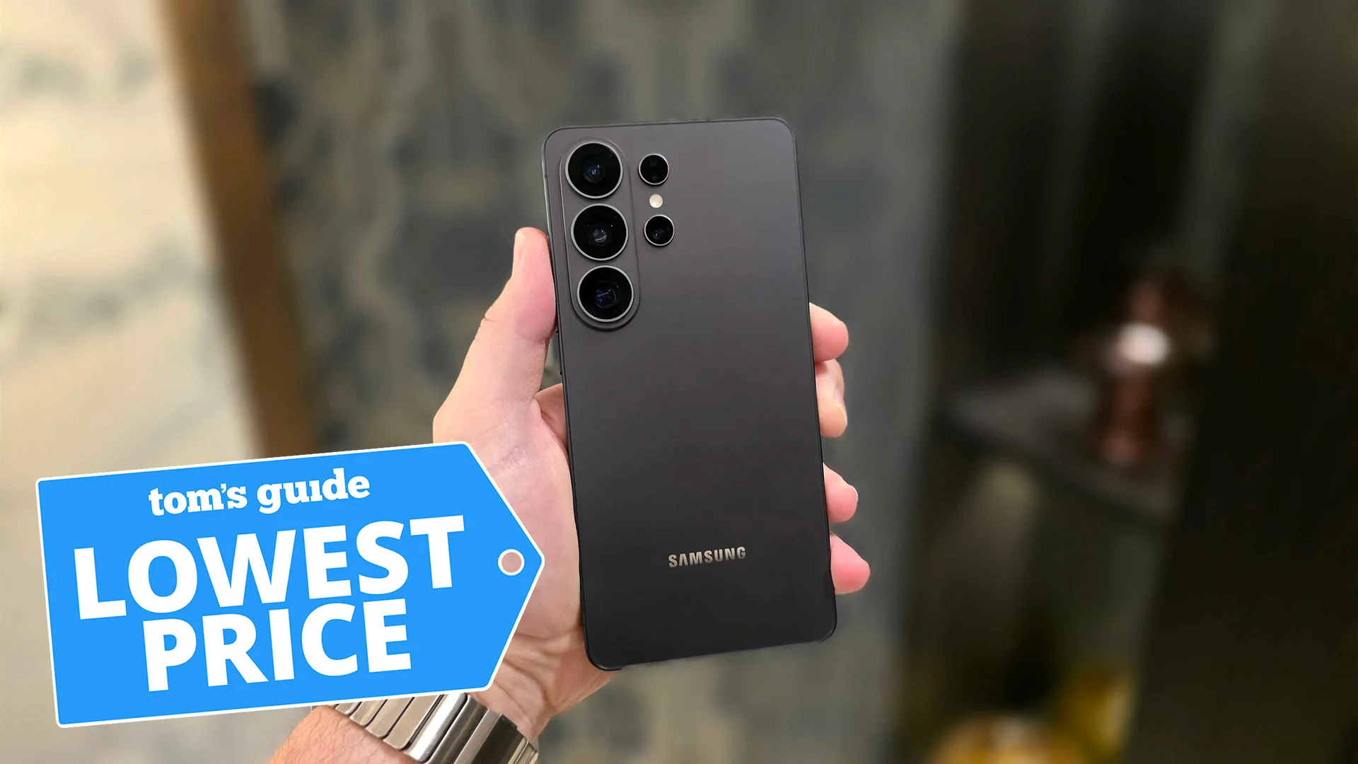 Samsung Galaxy S26 Ultra in hand with Tom's Guide 'Lowest Price' badge overlaid